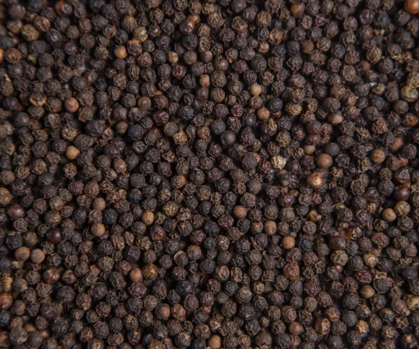 Black milled pepper corns as a background . High quality photo